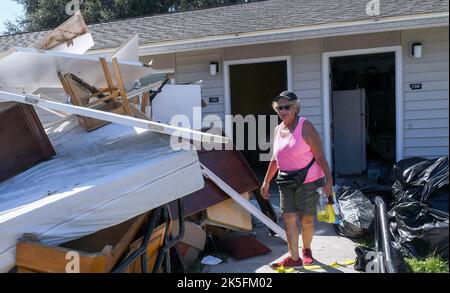 Kissimmee, Stati Uniti. 07th Ott 2022. Mirta Marangi si trova di fronte a un mucchio di mobili che è stato rovinato quando diversi piedi di acqua dall'uragano Ian inondato il suo appartamento al Kissimmee Homes Apartments a Kissimmee, Florida. La maggior parte degli appartamenti ha subito notevoli danni da alluvione e i residenti sono stati ordinati ad evacuare le loro case entro oggi in modo che gli equipaggi possano iniziare il processo di pulizia e riparazione. Credit: SOPA Images Limited/Alamy Live News Foto Stock