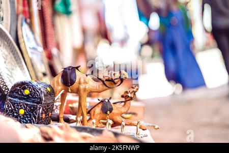 Piccolo cammello di dromedario in legno al mercato di strada in Marocco - concetto di shopping di viaggio con gli oggetti fatti a mano - filtro luminoso sul retro sfocato Foto Stock