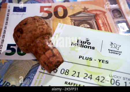 Biglietto della lotteria nazionale irlandese euro Millions con euro in contanti e champagne sughero significa biglietto vincente Foto Stock