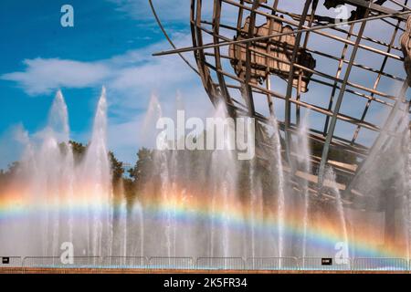 Un arcobaleno visibile visto nelle fontane che circondano l'Unisfera nel Flushing Meadows Corona Park nel Queens, New York City. Foto Stock