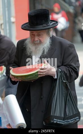 Un vecchio uomo ebraico ortodosso fa acquisti di generi alimentari poco prima del Sabbath. A Williamsburg, Brooklyn, New York City. Foto Stock