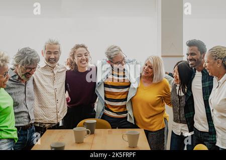 Felice gente multirazziale con età ed etnie diverse che si diverte a bere una tazza di caffè a casa Foto Stock