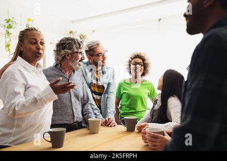 Colleghi multirazziali felici con età ed etnie differenti che hanno una rottura durante il tempo di lavoro Foto Stock