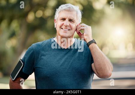 Senior man, fitness e musica esercizio all'aperto ascoltando la traccia audio allenamento per lo sport, la salute e il benessere. Corridore anziano in pensione sano Canada Foto Stock