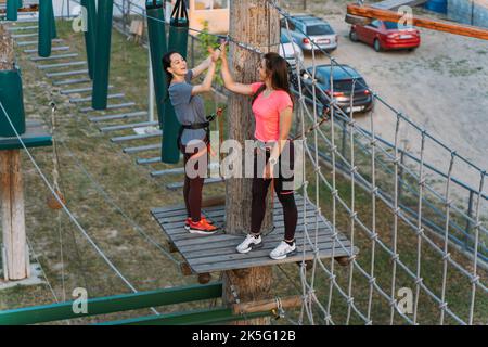 Due migliori amici si allenano sui corsi nel parco avventura Foto Stock