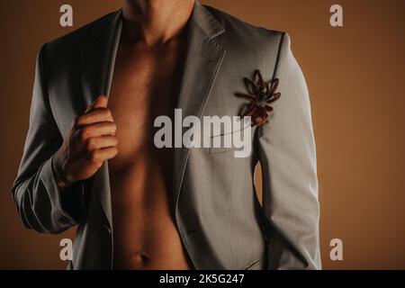 Primo piano di un uomo in tuta in piedi in studio con la sua tarantola Foto Stock