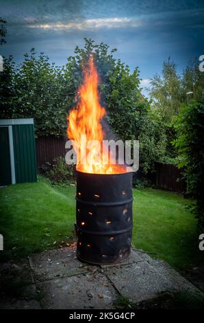 Un falò ardente in un tamburo di petrolio adattato in un giardino a Billingshurst, West Sussex, Regno Unito. Foto Stock