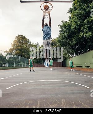 Il basket, giocatore e vincitore nel salto in campo, fa basket e punteggio, festeggiamenti e vittoria giocando contro la squadra. Competizione, giornata di gioco e palla punk Foto Stock