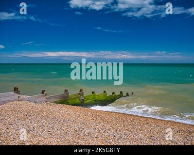 Una breakwater di legno sulla spiaggia di ciottoli a Kingsdown nel Kent. In una giornata limpida e soleggiata con cielo blu, nuvola chiara e mare turchese. Foto Stock