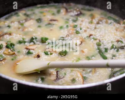 riso carnaroli mescolato in padella per risotto Foto Stock