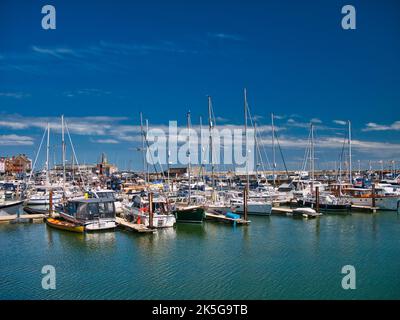 Barche a vela ormeggiate a Ramsgate Marina nel Kent, Regno Unito. In una tranquilla giornata di sole in estate con un cielo blu e nuvole di luce. Foto Stock