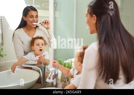 Dentista, denti e salute con una madre e un bambino spazzolando i denti nel bagno della loro casa insieme. Bambini, igiene orale e assistenza sanitaria con un Foto Stock