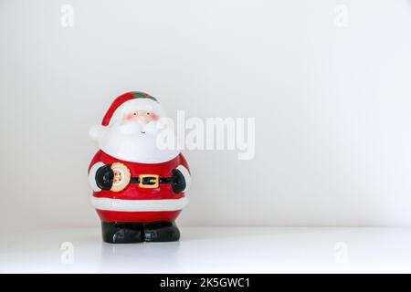 Natale Babbo Natale figurina isolato su sfondo bianco nevoso, ornamento decorativo festivo, copia spazio a destra Foto Stock