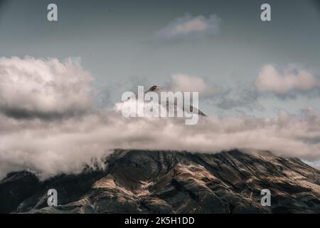 bellissimo paesaggio di cielo e nuvole tempesta ai piedi di una montagna impressionante con luci e ombre dal sole al tramonto in una calma e. Foto Stock