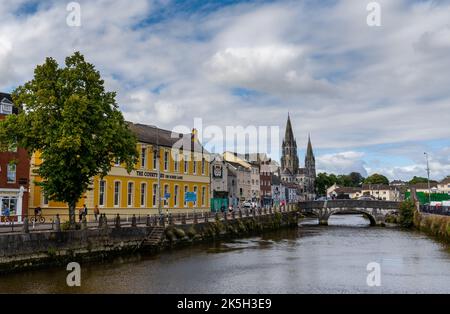 Cork, Irlanda - 16 agosto 2022: Il fiume Lee e il centro di Cork con le guglie della Cattedrale di Saint fin barre sullo sfondo Foto Stock