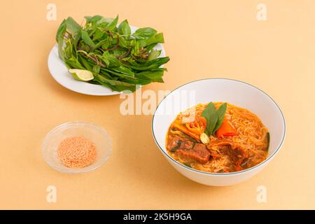 Hu tieu bo kho, stufato di manzo vietnamita con spaghetti di riso, cibo vietnamita isolato su sfondo beige, vista prospettica Foto Stock