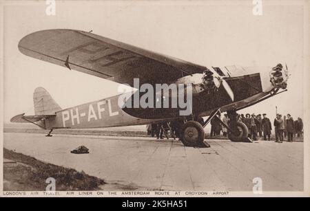 Inizio 1930s. Una cartolina vintage dal titolo "London’s Air Travel". Air Liner sulla Amsterdam Route all'aeroporto di Croydon'. Raffigura il aereo di linea Fokker F.XII ‘Leeuwerik’ (PH-AFL ) di KLM Royal Dutch Airlines. Quando il 6 aprile 1935 volava in scarsa visibilità tra Praga e Rotterdam via Lipsia ed Essen, questo aereo si è schiantato dopo aver colpito il fianco di una montagna vicino a Brilon, in Germania. Tutti i 7 passeggeri e l'equipaggio sono stati uccisi. Foto Stock