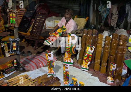 Venditore stradale che vende articoli decorativi in bancarelle temporanee pavimentazione Foto Stock