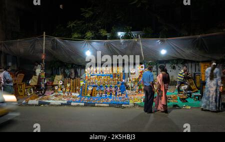 Venditore stradale che vende articoli decorativi in bancarelle temporanee pavimentazione Foto Stock