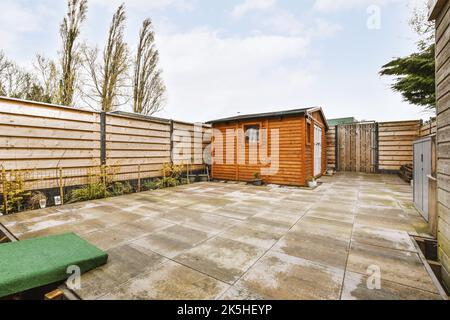 Ampio garage con porta bianca chiusa e pareti in legno con appendiabiti Foto Stock