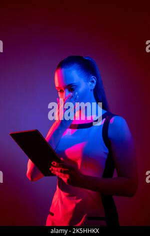cyber attack truffa digitale spaventato neon donna tablet Foto Stock