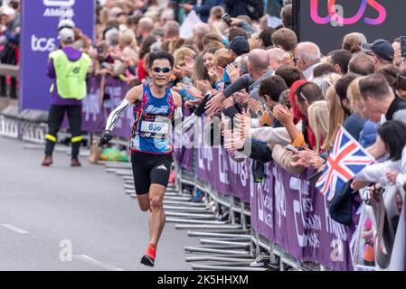 Song-ming Syu, runner del club che corre nella corsa su strada TCS London Marathon 2022 a Tower Hill, City of London, UK. Interagire con una grande folla, supporto Foto Stock