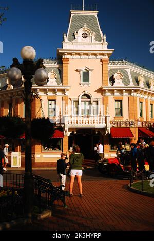 I turisti camminano per Main Street USA, l'area commerciale e dello shopping di Disneyland ad Anaheim, California, in una giornata di sole estate Foto Stock
