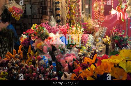 Venditore stradale che vende articoli decorativi in bancarelle temporanee pavimentazione Foto Stock