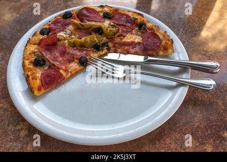 Una pizza salame mezza mangiata, Baviera, Germania Foto Stock