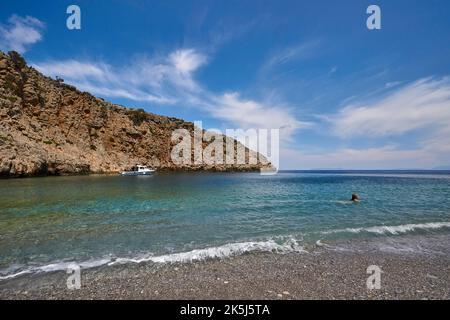 Menies, Rodopou, baia dei sogni, spiaggia di ciottoli, barca singola, persona in acqua, mare cristallino, mare verde, mare turchese, mare blu, Doric Foto Stock