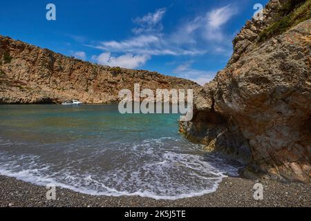 Menies, Rodopou, baia dei sogni, barca singola all'ancora, spray, rocce, spiaggia di ciottoli, mare cristallino, Mare verde, mare turchese, mare blu, Doric Foto Stock