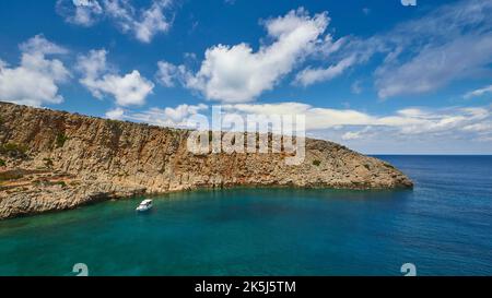 Menies, Rodopou, baia dei sogni, spiaggia di ciottoli, barca singola all'ancora, mare cristallino, mare verde, mare turchese, mare blu, Sito archeologico dorico Foto Stock