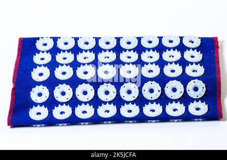 Tappetino massaggiante con aghi. Isolato su sfondo bianco. Rullo ad ago ortopedico per il collo, isolato Foto Stock