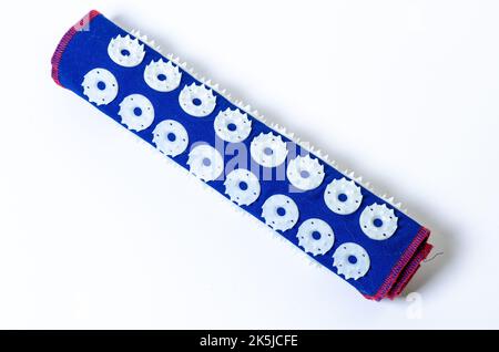 Tappetino massaggiante con aghi. Isolato su sfondo bianco. Rullo ad ago ortopedico per il collo, isolato Foto Stock