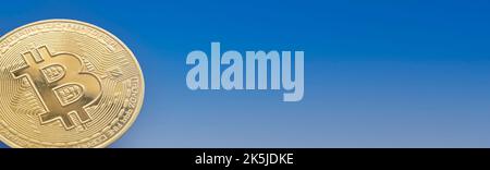 primo piano di una moneta bitcoin su sfondo blu sfumato, copia spazio, panorama orizzontale Foto Stock