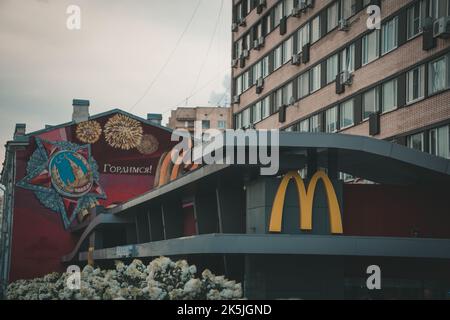 Il primo ristorante McDonalds nell'Unione Sovietica, accanto alla propaganda sovietica, rende interessante il contrasto. Mosca, Russia. Foto Stock