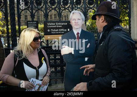 Londra, Regno Unito. 8th ottobre 2022. Un ufficiale della polizia metropolitana chiede ai manifestanti che formano una catena umana intorno al Parlamento di chiedere il rilascio di Julian Assange, un whistleblower imprigionato, per muoversi. Il 17th giugno 2022 l'ex segretario di casa Priti Patel ha approvato un ordine di estradizione per estradare Julian Assange negli Stati Uniti. Credit: Notizie dal vivo di Mark Kerrison/Alamy Foto Stock