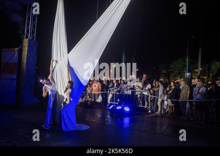 Malaga, Spagna. 08th Ott 2022. Gli acrobati si esibiscono in Plaza de la Marina mentre partecipa all'evento 'Noche en Blanco' nel centro della città, dopo essere stata sospesa a causa della pandemia del coronavirus per due anni. La tredicesima edizione di 'Noche en Blanco' accoglie una nuova cultura notturna in cui persone e visitatori potranno godere di spettacoli, musica e attività culturali gratuite nei musei fino a mezzanotte. Quest'anno il tema ufficiale scelto è costituito dai quattro elementi della natura: Fuoco, terra, acqua e aria. Credit: SOPA Images Limited/Alamy Live News Foto Stock