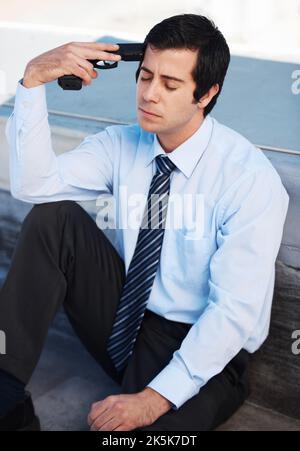 L'unica via d'uscita. Un uomo corporativo depresso che mette una pistola alla sua testa. Foto Stock