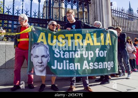 Londra, Regno Unito. 08th Ott 2022. I sostenitori di Julian Assange hanno una bandiera che chiede all'Australia di schierarsi per Assange durante la protesta. Migliaia di persone hanno formato una catena umana intorno alle Camere del Parlamento che si estende attraverso Vauxhall Bridge e Westminster Bridge, chiedendo che il governo britannico rilasci il fondatore di WikiLeaks Julian Assange. Credit: SOPA Images Limited/Alamy Live News Foto Stock