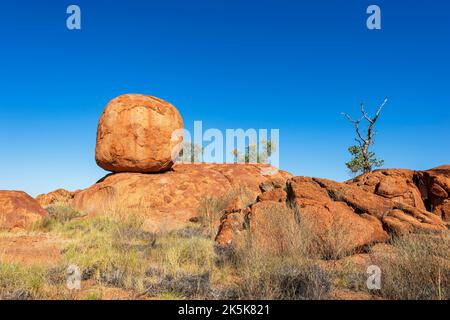 Boulder di granito rotondo equilibrato eroso a Devil's Marbles, una destinazione turistica popolare, Northern Territory, NT, Australia Foto Stock