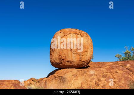 Boulder di granito rotondo equilibrato eroso a Devil's Marbles, una destinazione turistica popolare, Northern Territory, NT, Australia Foto Stock