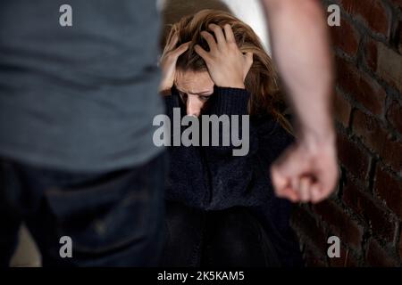 Non di nuovo... ha abusato la giovane donna con le mani nei suoi capelli mentre il suo abuser si alza sopra di lei. Foto Stock