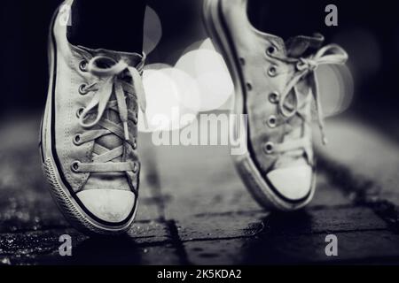 Galleggiando per le strade della città. Immagine ritagliata di una persona che indossa scarpe da ginnastica in piedi per strada. Foto Stock