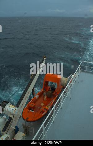 Vista di una barca di salvataggio delle navi mercantili fissata sul ponte della barca Foto Stock