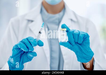 Covid, il vaccino e le mani di un medico che tiene l'ago e la siringa per un'iniezione. Medicina, scienza e primo piano di operatore sanitario con Foto Stock
