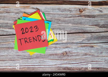 Nuovo anno 2023 nuovo concetto di trend. Note colorate appiccicose su sfondo di legno. Foto Stock