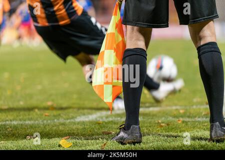 Il calciatore prende l'angolo. Dettaglio delle gambe dell'arbitro durante la partita di calcio. Foto Stock