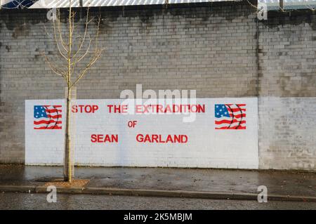 Murale su un muro fuori della Belfast Falls Road - 'Stop l' estradizione di Sean Garland' Foto Stock