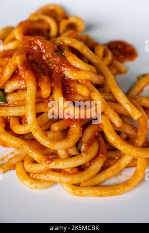 Pici tutti gli Aglione Pasta tradizionale di aglio e pomodoro arrotolato a mano di Siena, Toscana, Italia Foto Stock